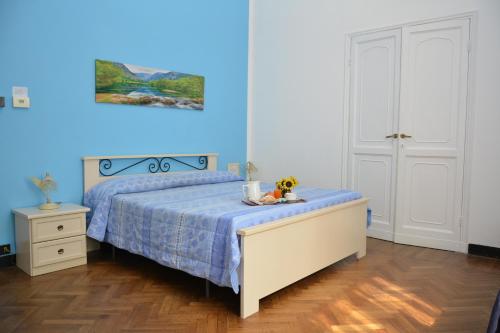 a bedroom with a bed and a blue wall at Family Hotel Balbi in Genoa