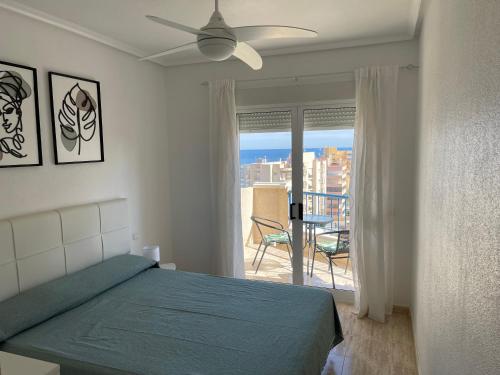 um quarto com uma cama e vista para uma varanda em Sea-view 3-bedroom apartment near Alicante em Arenales del Sol