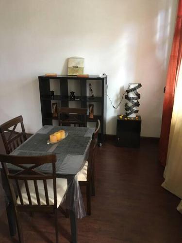 a dining room with a table and chairs and a shelf at Modern and Cozy Apartment in Quatre Bornes in Quatre Bornes