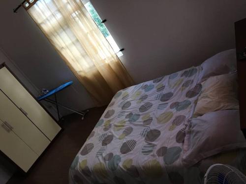 a bedroom with a bed and a window with a curtain at Modern and Cozy Apartment in Quatre Bornes in Quatre Bornes