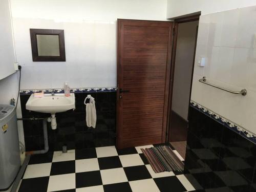 a bathroom with a sink and a wooden door at Modern and Cozy Apartment in Quatre Bornes in Quatre Bornes