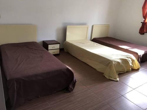 a bedroom with two beds and a tiled floor at Modern and Cozy Apartment in Quatre Bornes in Quatre Bornes