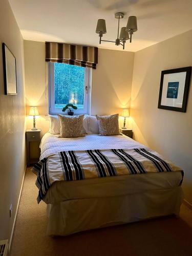 a bedroom with a bed with two pillows and a window at Gleneagles Lettings in Auchterarder