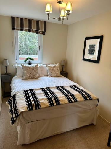 a bedroom with a large bed with a window at Gleneagles Lettings in Auchterarder