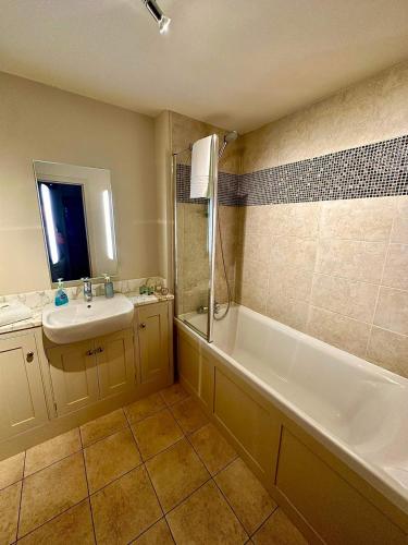 a bathroom with a tub and a sink and a bath tub at Gleneagles Lettings in Auchterarder