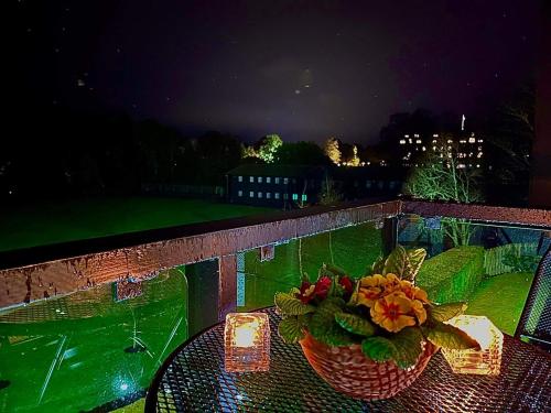 a table with a basket of flowers on a balcony at Gleneagles Lettings in Auchterarder