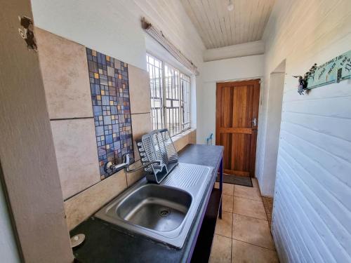 baño pequeño con lavabo y ventana en Sabie Peak View, en Sabie