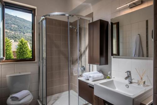 uma casa de banho com um chuveiro, um lavatório e um WC. em Villa Ete Premier Luxury Villa em Stalida