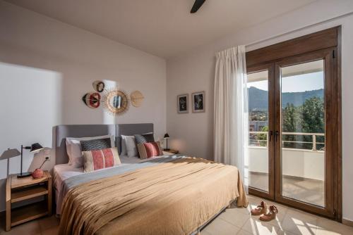 a bedroom with a bed and a large window at Villa Ete Premier Luxury Villa by Prime Stay in Stalida