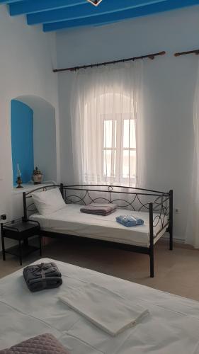 a bedroom with two beds and a window at Stathis Apart 2 in Amorgos