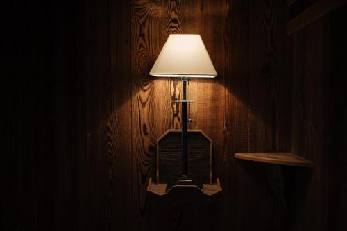 a lamp on a wall in a dark room at Coeur des Neiges in Saint-Gervais-les-Bains