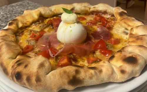 a pizza with a dollop of sour cream on top at Residenza Il Capitano in San Benedetto Po