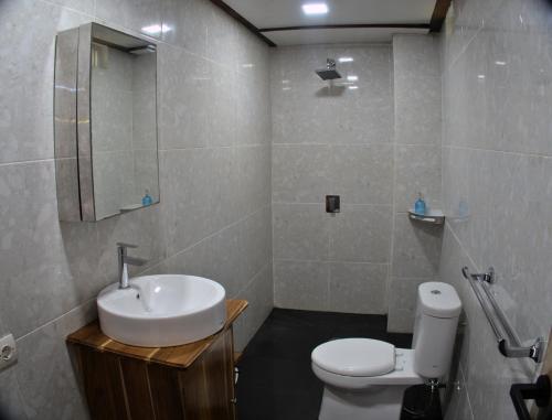 a bathroom with a sink and a toilet at 3 Waves Hotel in Huu