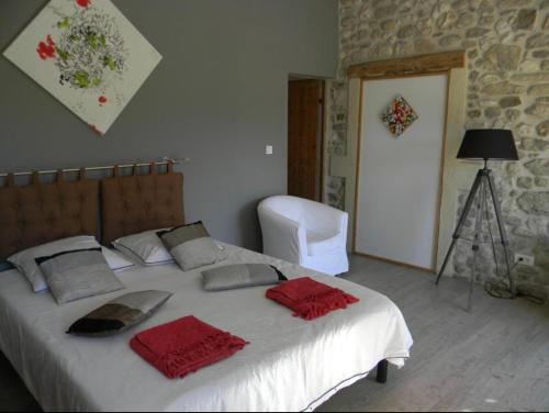 een slaapkamer met een wit bed met rode handdoeken erop bij La Grange de Marie in Valaurie