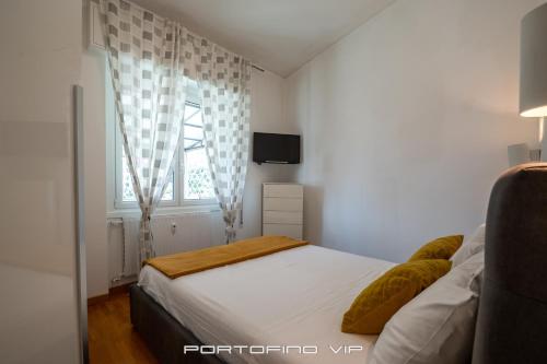 a small bedroom with a bed and a television at Seaview Flat by PortofinoVip AC, Parking,Terrace in Rapallo