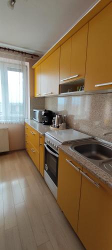 a kitchen with yellow cabinets and a stove at Central Vanilla Oradea in Oradea