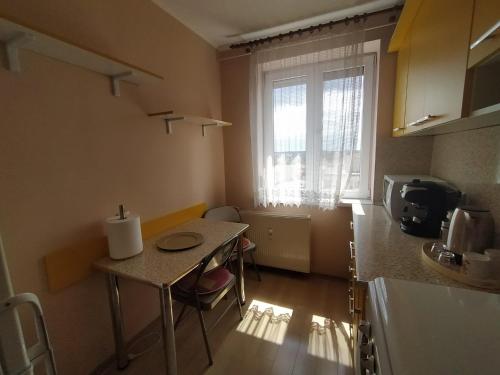 a small kitchen with a table and a window at Central Vanilla Oradea in Oradea