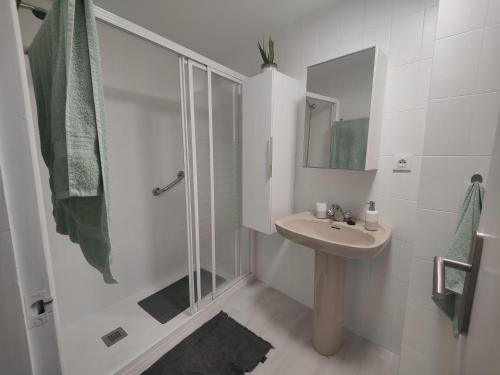 y baño blanco con lavabo y ducha. en Vivienda en el centro histórico con ascensor, en Jaén