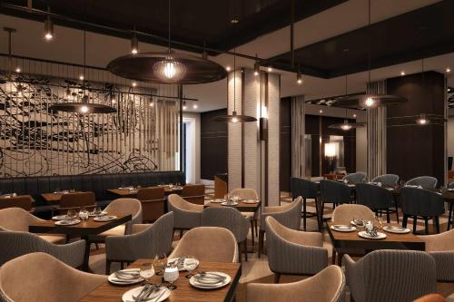 a restaurant with wooden tables and chairs and lights at Nashville Marriott at Vanderbilt University in Nashville