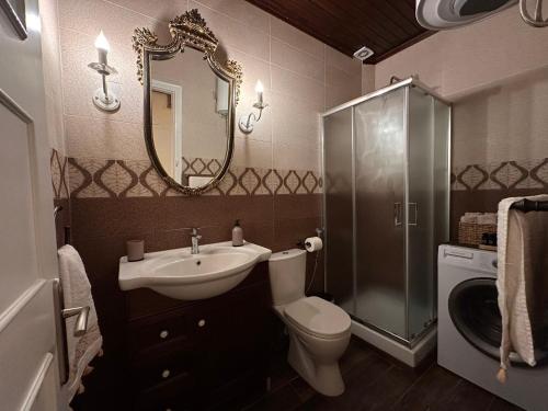 a bathroom with a sink toilet and a mirror at The Odyssey Holiday Home - Agios Ioannis, Pelion in Agios Ioannis Pelio