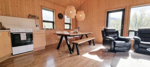 uma cozinha com uma mesa, um fogão e cadeiras em Kirkjubraut - Church street em Talknafjordur