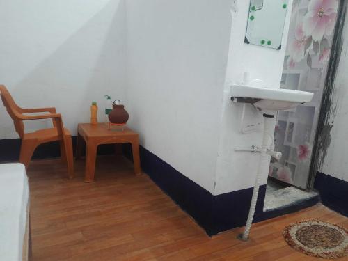a bathroom with a sink and a chair and a table at OYO HOME 80891 Hotel Always Welcome in Jewar