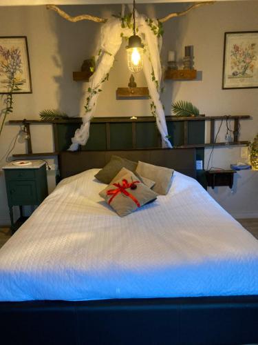 - un lit blanc avec une archet au-dessus dans l'établissement L'intimité de l'Ô, à Merbes-le-Château