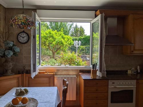 a kitchen with a table and a large window at Casa Rural Bilbao Caserio Gondra Alquiler Habitaciones in Mungia