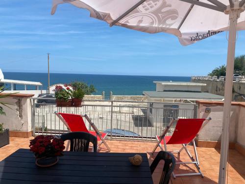 a patio with a table and chairs and an umbrella at Terrazza mare home in Rodi Garganico