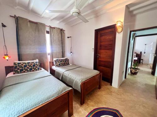 a bedroom with two beds and a mirror in it at MOYO apartment in Pwani Mchangani