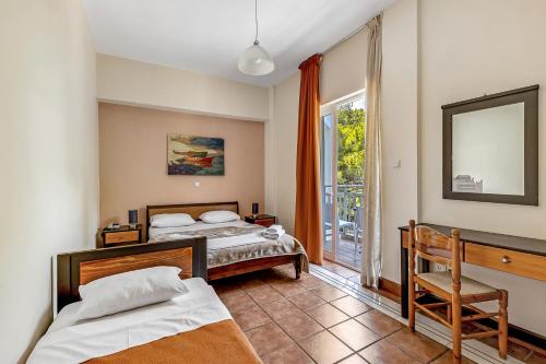 a bedroom with two beds and a window at Golden View in Poros