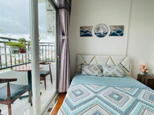 una camera con letto e balcone di ALPHA HOMESTAY MARINA 2 Phòng Ngủ View Sông a Ấp Ðông An (1)