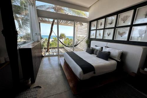 a bedroom with a bed with a view of the ocean at TULUM Beachfront Villa I'Ik by Casa Xuul Tulum in Tulum