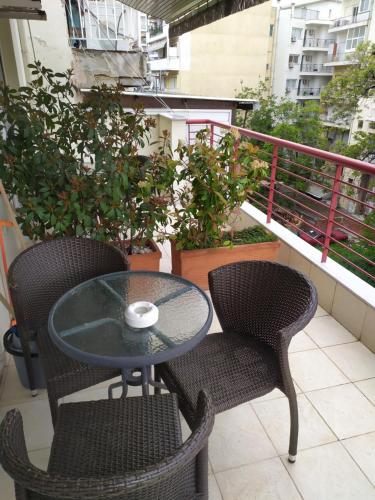 a table and two chairs on a balcony at Tzikas apARTments in Thessaloniki