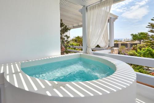 a hot tub on the balcony of a house at Orabel Suites Santorini (Adults Only) in Perivolos