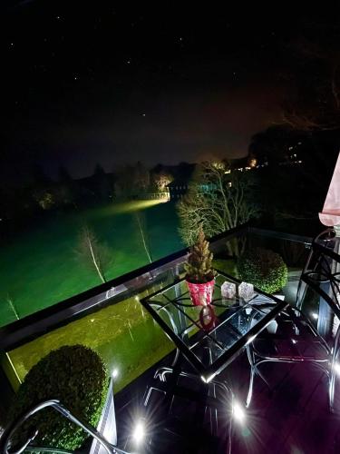 a table on a balcony with a view of a pond at Gleneagles Lettings in Auchterarder