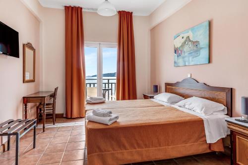 a bedroom with a large bed and a balcony at Golden View in Poros