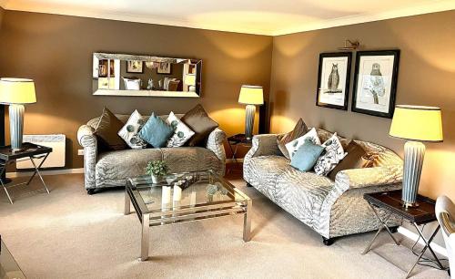 a living room with two couches and a coffee table at Gleneagles Lettings in Auchterarder