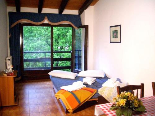 ein Wohnzimmer mit einem Sofa und einem Fenster in der Unterkunft Villa (apartment F) — Pool — Lake Idro in Vesta