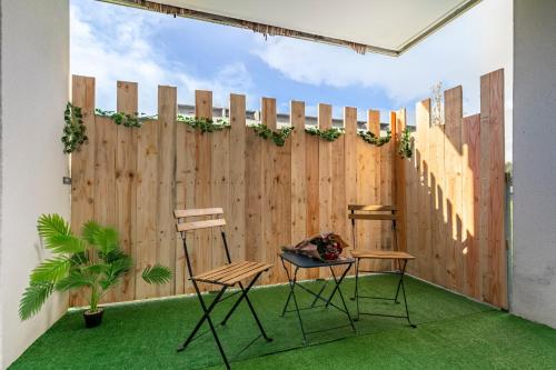 a patio with two chairs and a fence at Bali Chic in La Hourcade