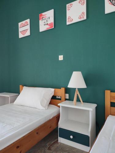 a bedroom with two beds and a table with a lamp at Filoxenia Apartments in Riza