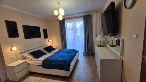 - une chambre avec un lit et une couverture bleue dans l'établissement Pokoje Gościnne Ster, à Władysławowo
