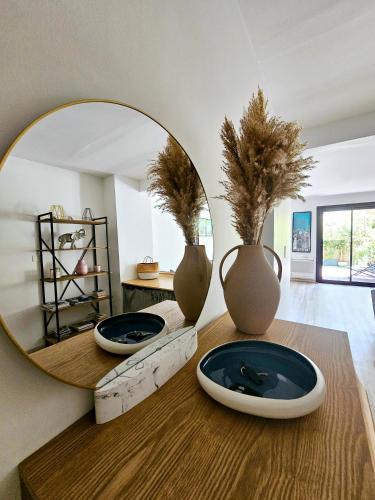 un miroir posé sur une table en bois avec des vases dans l'établissement Jardin Privé ds le Centre de Cassis - Parking - Plage à 500m, à Cassis