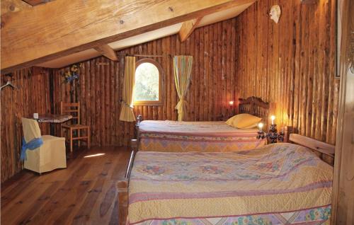 een slaapkamer met 2 bedden en een houten muur bij Awesome Home In Grillon With Heated Swimming Pool in Grillon