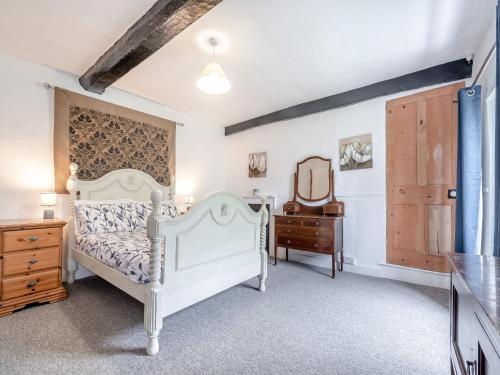 a bedroom with a white bed and a dresser and a mirror at Bengoughs Annexe in Berkeley