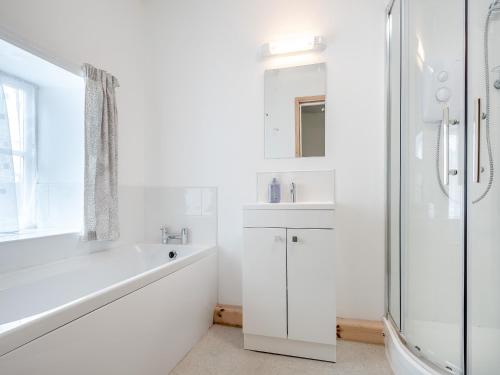 a white bathroom with a tub and a sink and a shower at Bengoughs Annexe in Berkeley