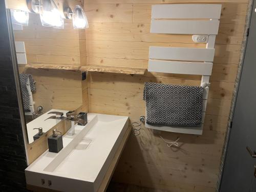 a bathroom with a sink and a mirror at appartement T4 type chalet pra-loup in Uvernet