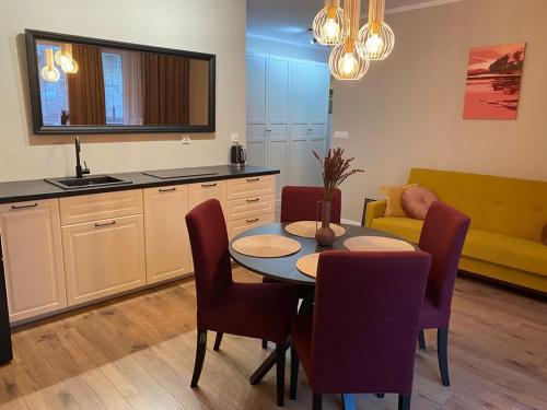 a kitchen and dining room with a table and chairs at Apartament Olecko Nad Jeziorem in Olecko