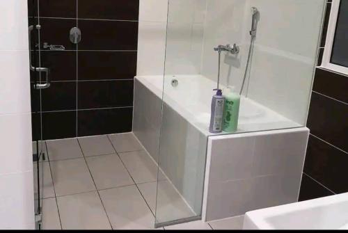 a bathroom with a shower with a bottle of soap at Cozy 3 Guests High Floor at Puteri Harbour L22 in Nusajaya