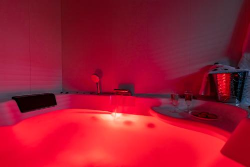 Cette chambre dispose d'une baignoire rouge avec un lavabo. dans l'établissement Bali Chic, à La Hourcade